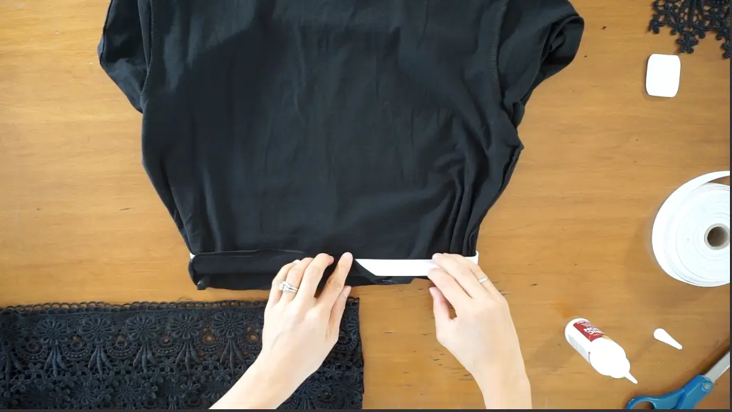 Fold the shirt bottom over the elastic band to cover with fabric. Secure with fabric glue.