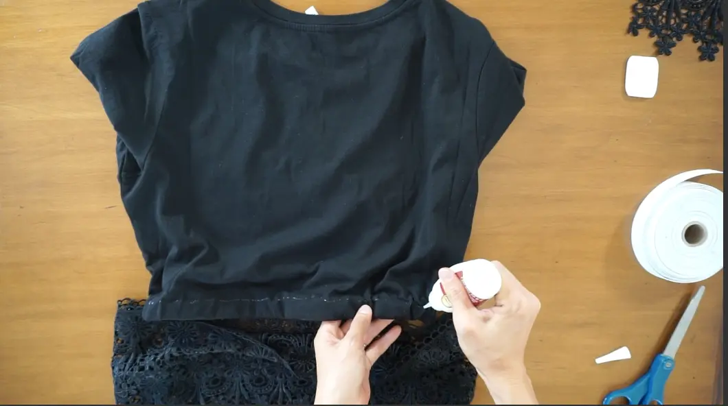 Use fabric glue to attach the lace trim to the bottom of the shirt and finish the diy lace peplum top.