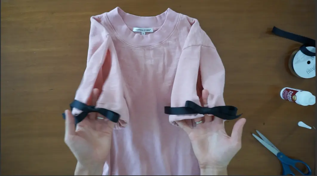 Tie the sleeve with a bow to finish the shirt upcycle.