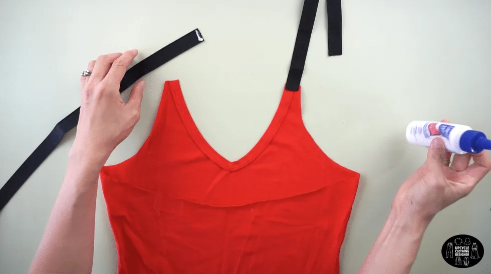 Use fabric glue to attach the elastic band to the front of the tank top to make shoulder straps