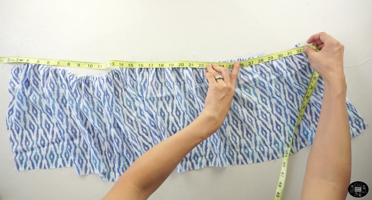 Pull on the back threads to bunch up the fabric and reduce the length to 34”.