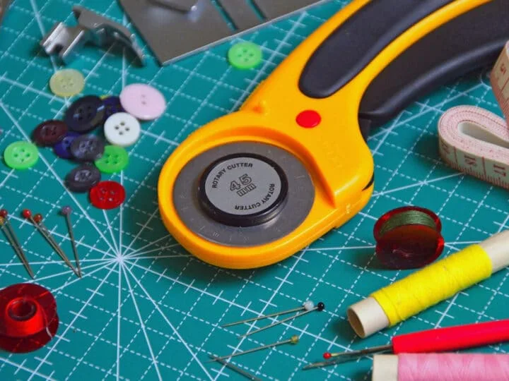 rotary cutter and fabric scissors on cutting board