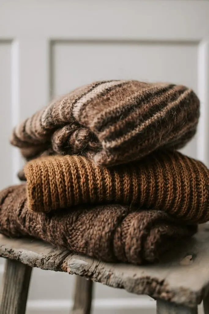 stacked sweaters on stool