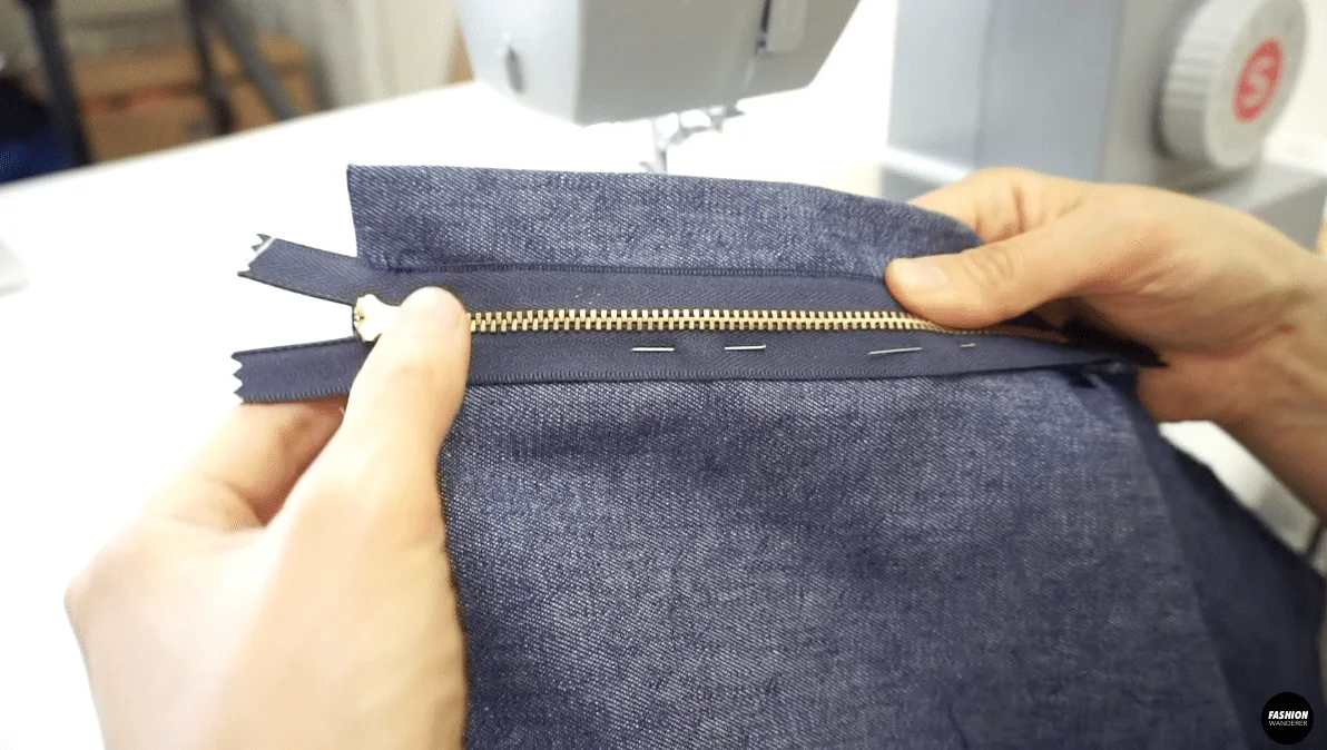 Stitch down the right side of the zip close to the zipper teeth and second row of stitching on the edge of the zipper tape.