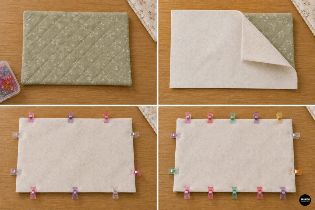 Quilted floral exterior and lining pieces layered right sides together, secured with sewing clips, and prepared for stitching around the diaper clutch.