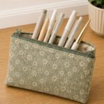 Handmade sage green floral zipper pencil pouch filled with pens and markers, an easy beginner sewing project for back-to-school supplies.